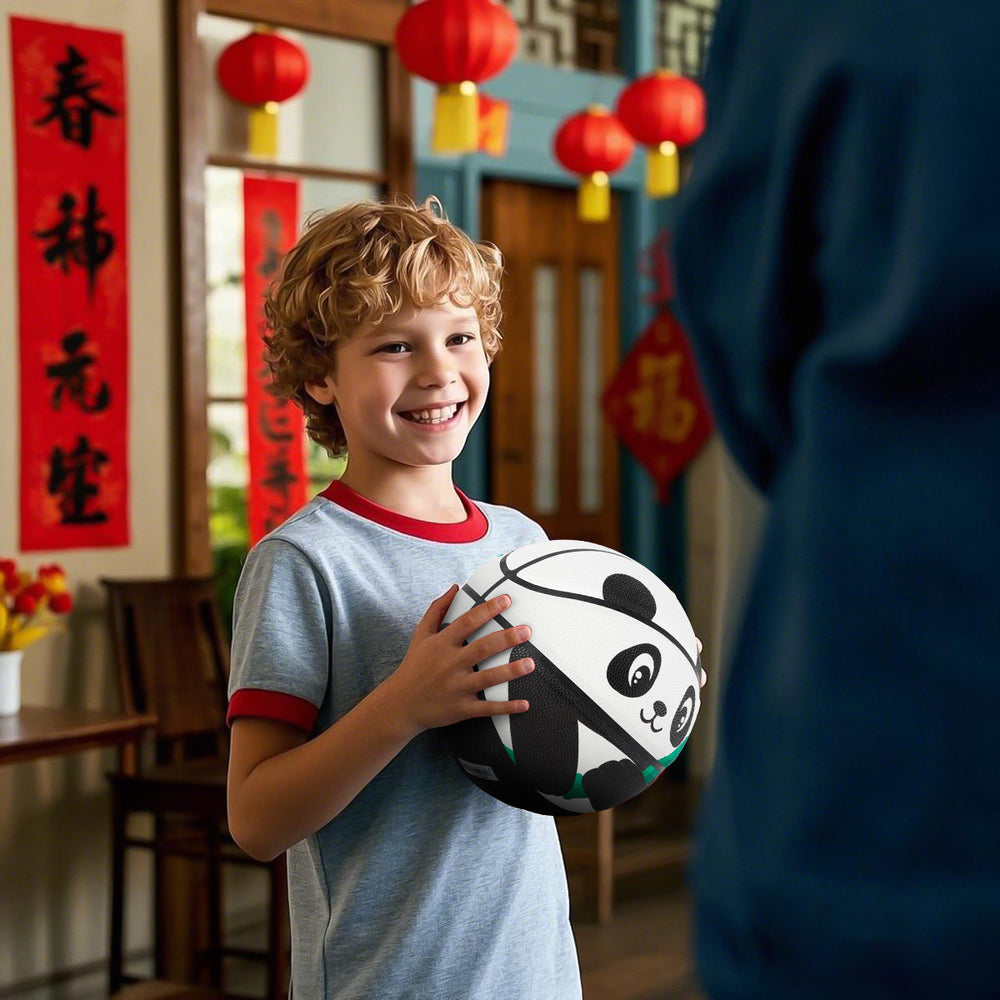 A white child is holding Kuangmi Panda Basketball in a Chinese-style room